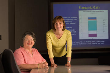 Cathy J. Bradley, Ph.D. and Phyllis C. Katz, J.D. pose at a conference table