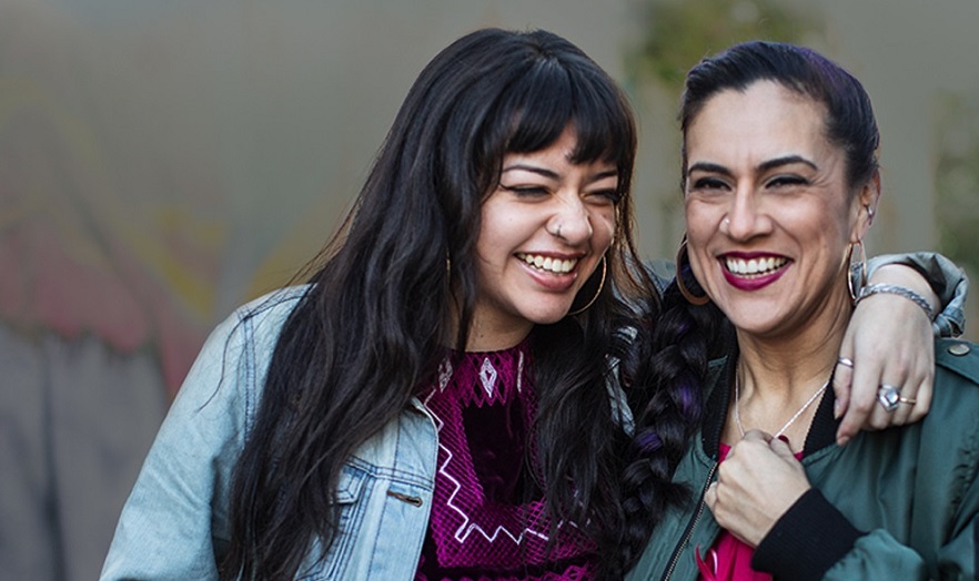 Two smiling, Caucasian women embracing