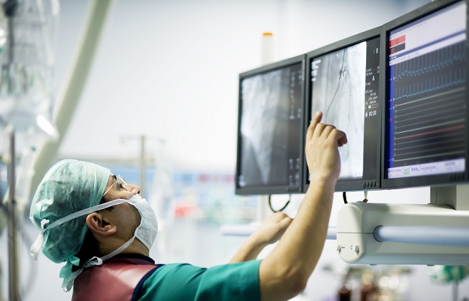A surgeon looking at a screen in the operating room