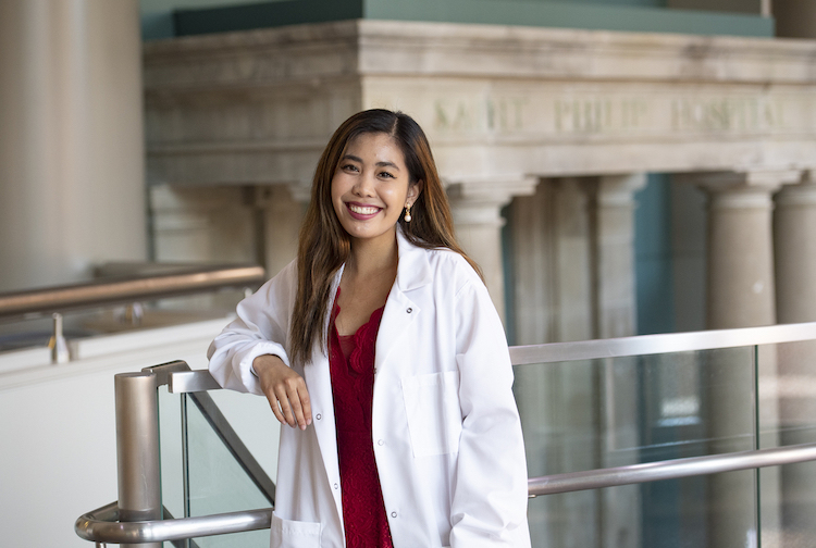 Young woman in lab coat smiling