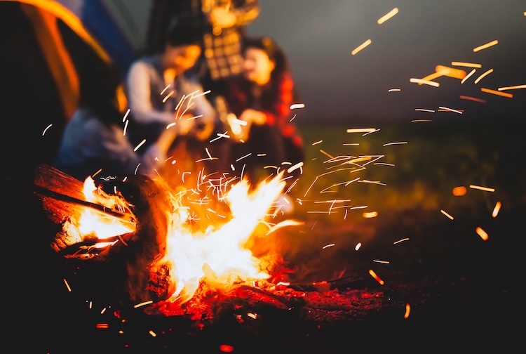 Sparking bonfire with  people sit around it