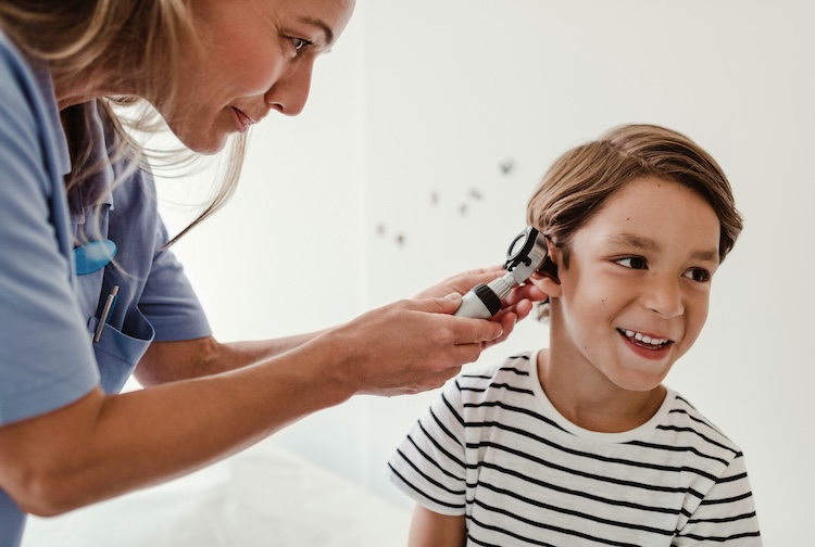 doctor looks inside child's ear