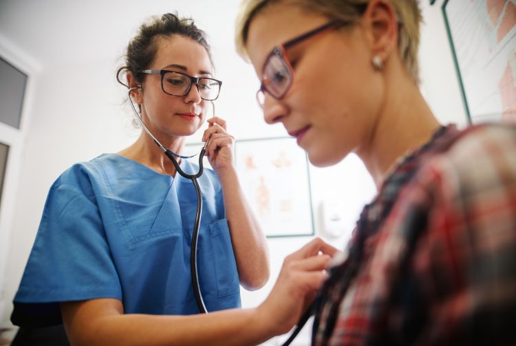 Healthcare provider uses a stethoscope to listen to a patients heart