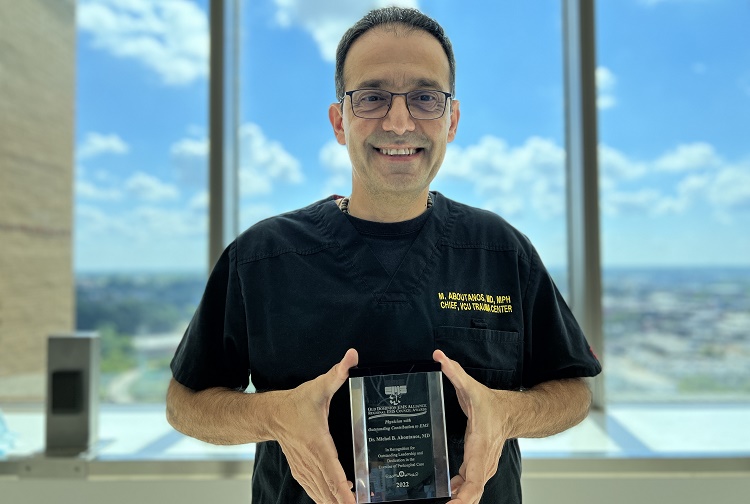 Michel Aboutanos, MD holding "Outstanding Contribution to EMS by a Physician" award