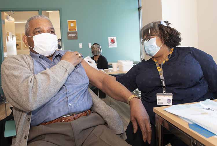 Kimberly Battle vaccinates her father, Phillip Battle
