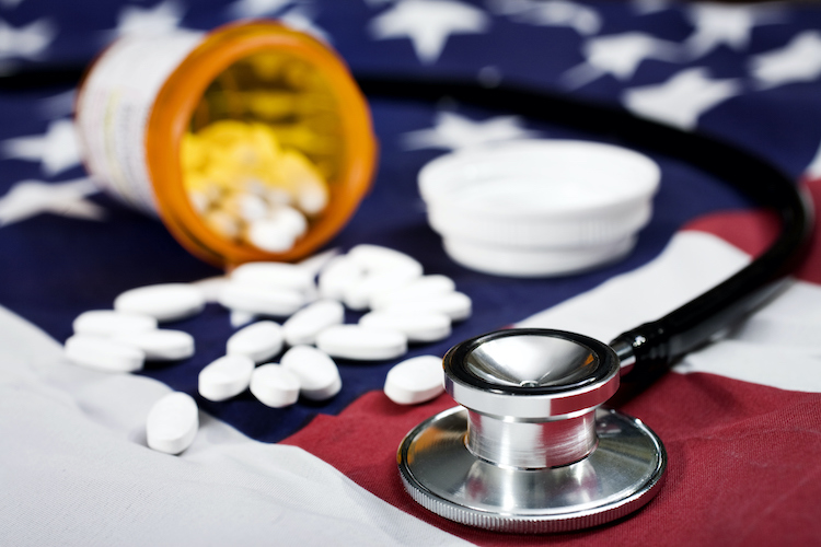 Pills and a stethoscope on an American Flag